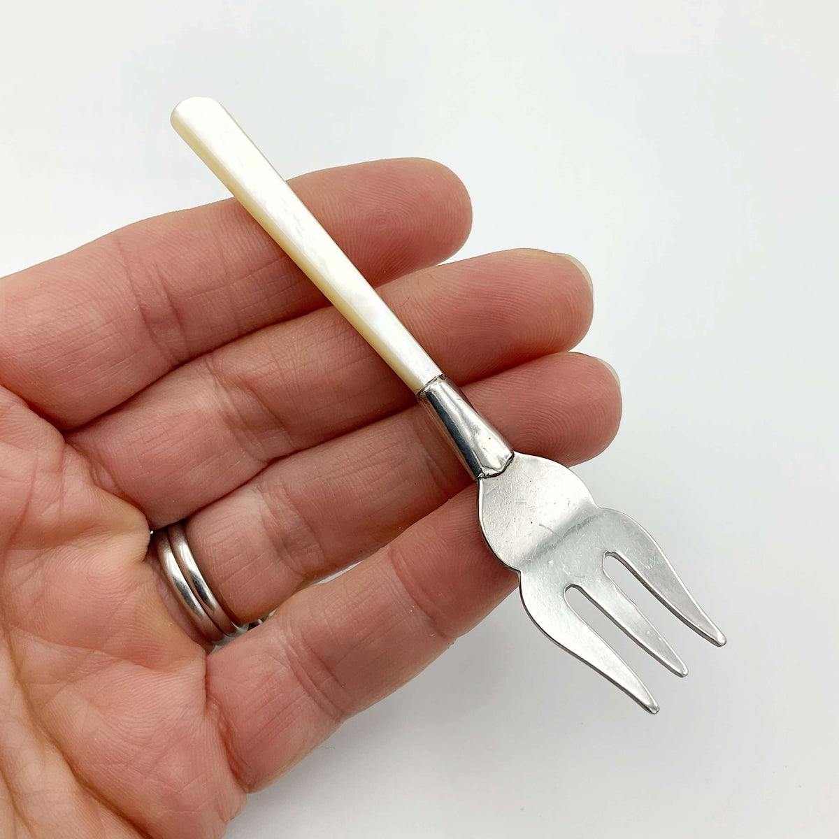 Small silver-plated pickle fork with a mother of pearl handle, ideal for serving olives and pickles, from Beeches Vintage.