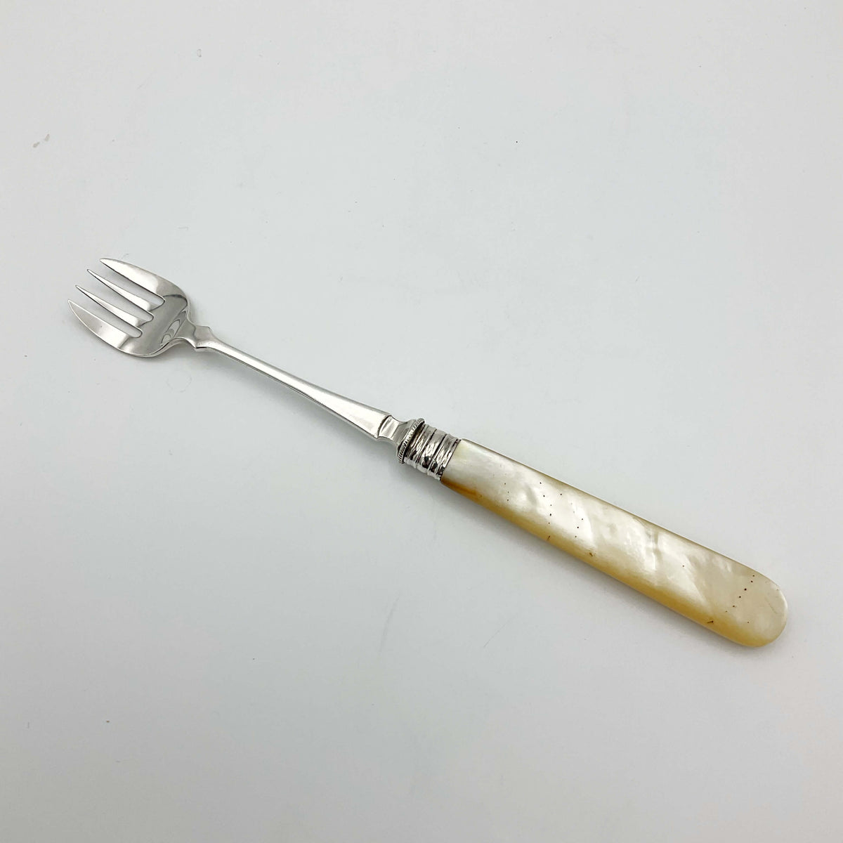 Vintage silver-plated pickle fork with a mother of pearl handle, by Beeches Vintage, displaying intricate details and elegant craftsmanship.