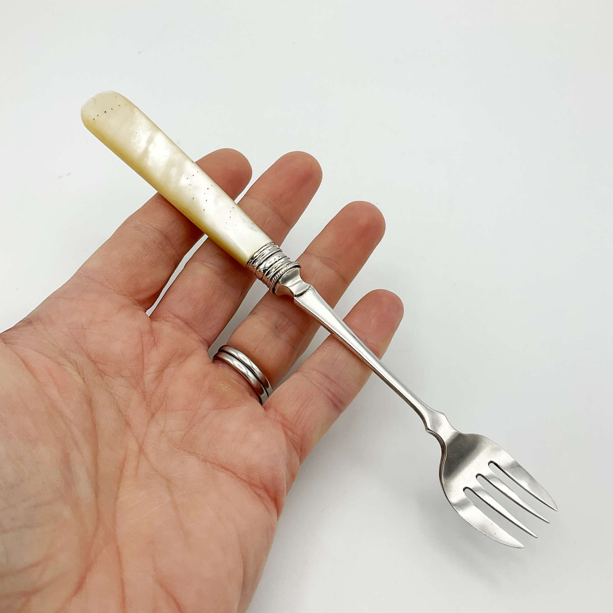 Vintage silver-plated pickle fork with a mother of pearl handle by Beeches Vintage, showcasing elegant antique silverware design.