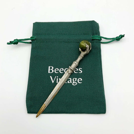 Sword shaped silver plated letter knife on a green gift bag