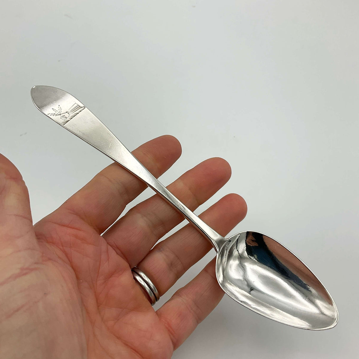 Antique 1788 solid silver dessert spoon with ornate handle, vintage Beeches Silver collectible on a white background.