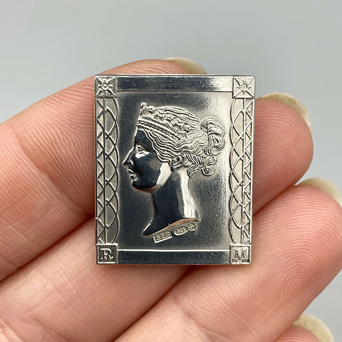 Sterling silver Queen Victoria postage stamp medal with detailed vintage design by Beeches Vintage, shown in close-up.