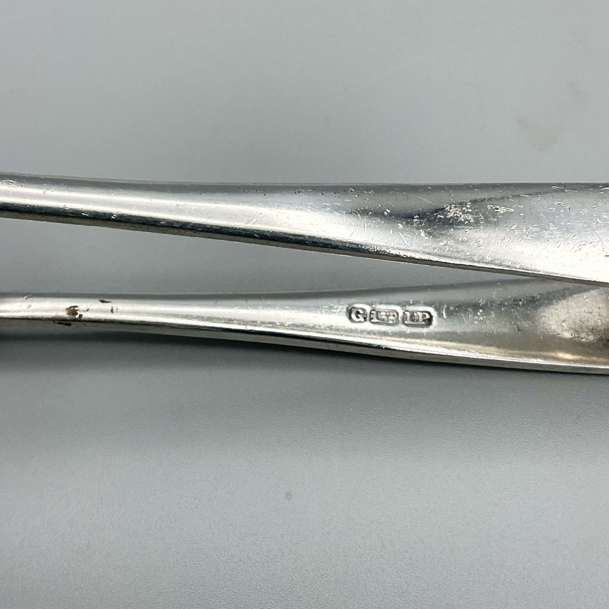 Vintage silver plated Beeches Vintage sugar tongs with ornate design, showcasing elegant craftsmanship on a white background.