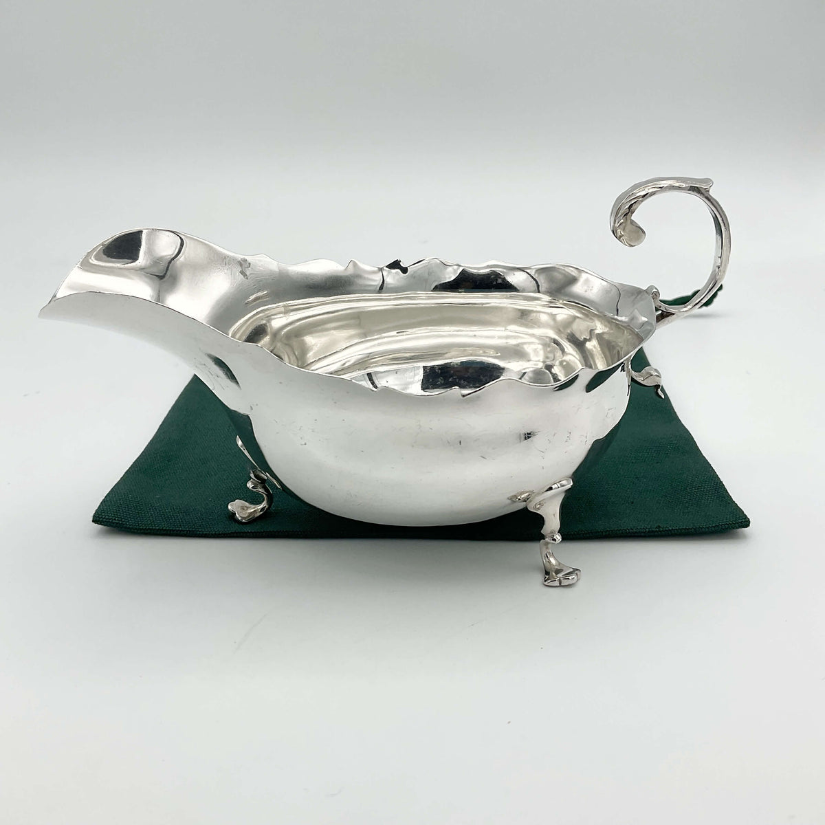 Antique 1902 solid silver sauce boat with ornate design, crafted by Beeches Vintage, showcasing elegant vintage silverware.