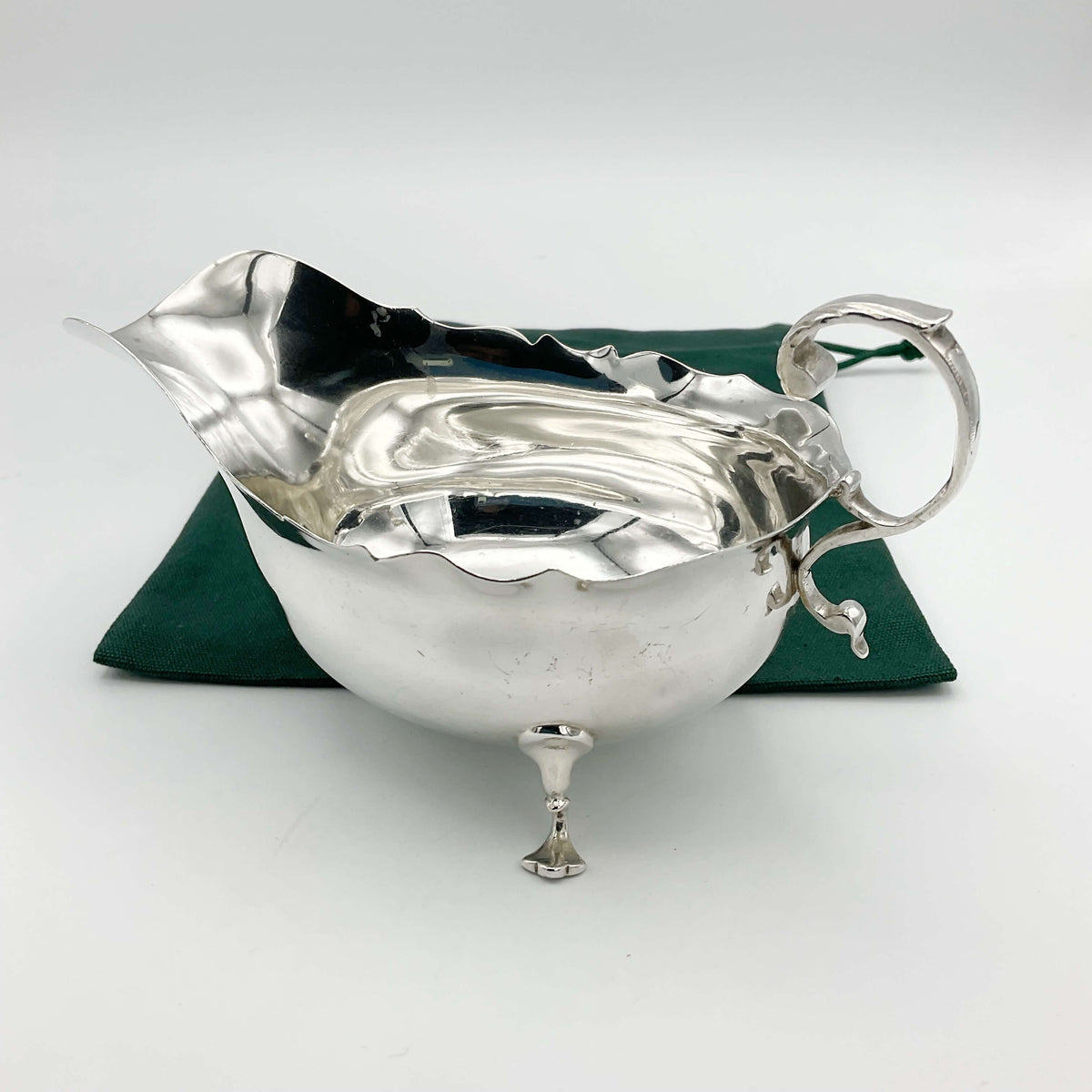 Antique 1902 solid silver sauce boat by Beeches Vintage, featuring elegant design and polished finish on a white background.