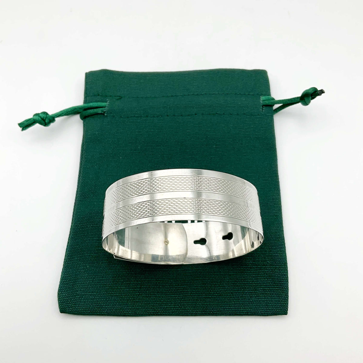 Silver adjustable bangle bracelet by Beeches Vintage, featuring a sleek, minimalist design with smooth curves and open ends.