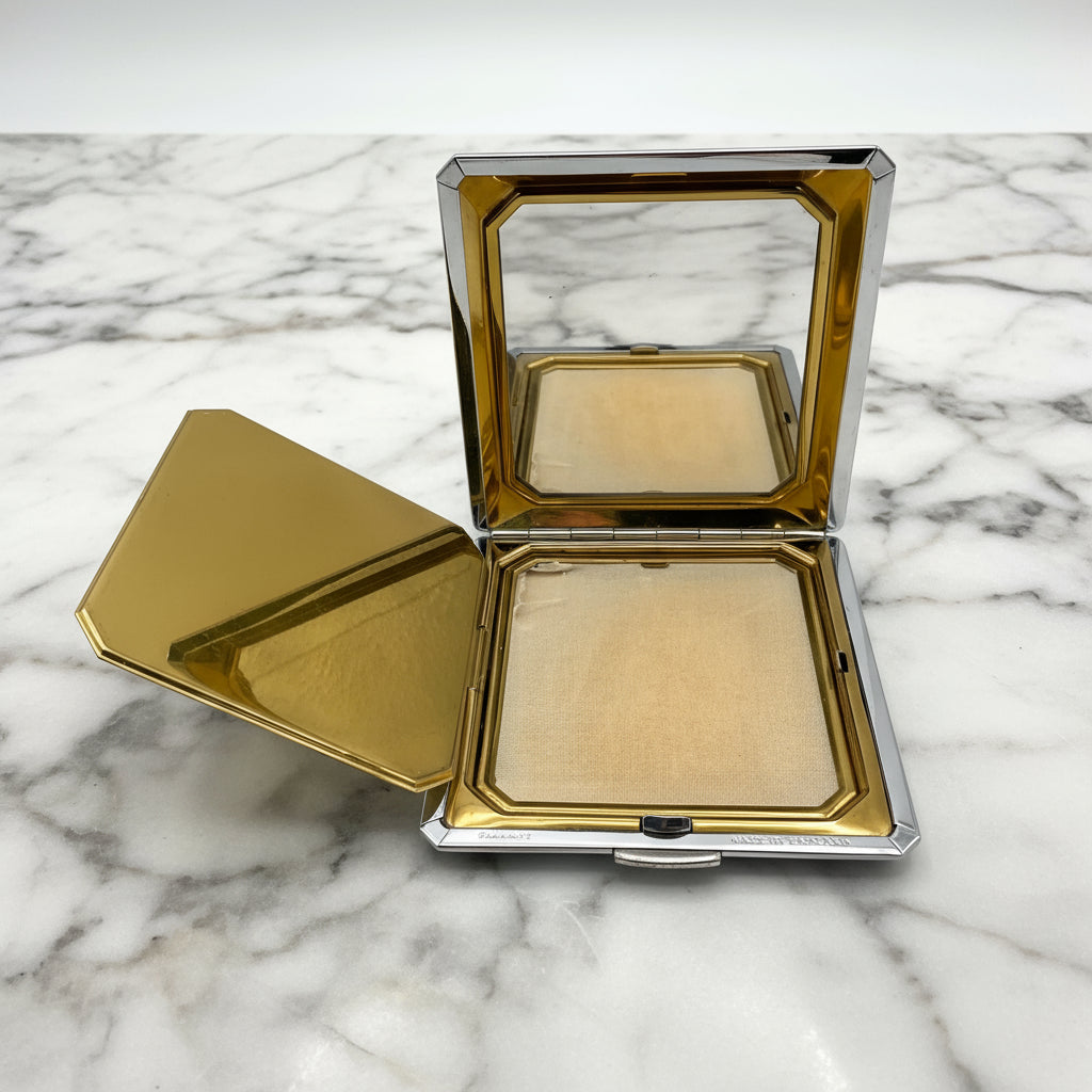 open powder compact on a marble surface