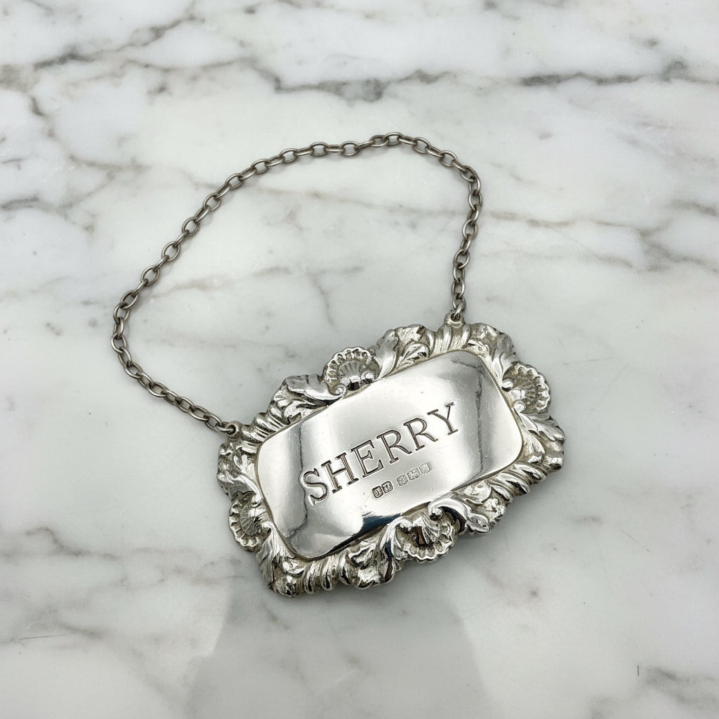 A shiny Sherry decanter label on a marble background.
