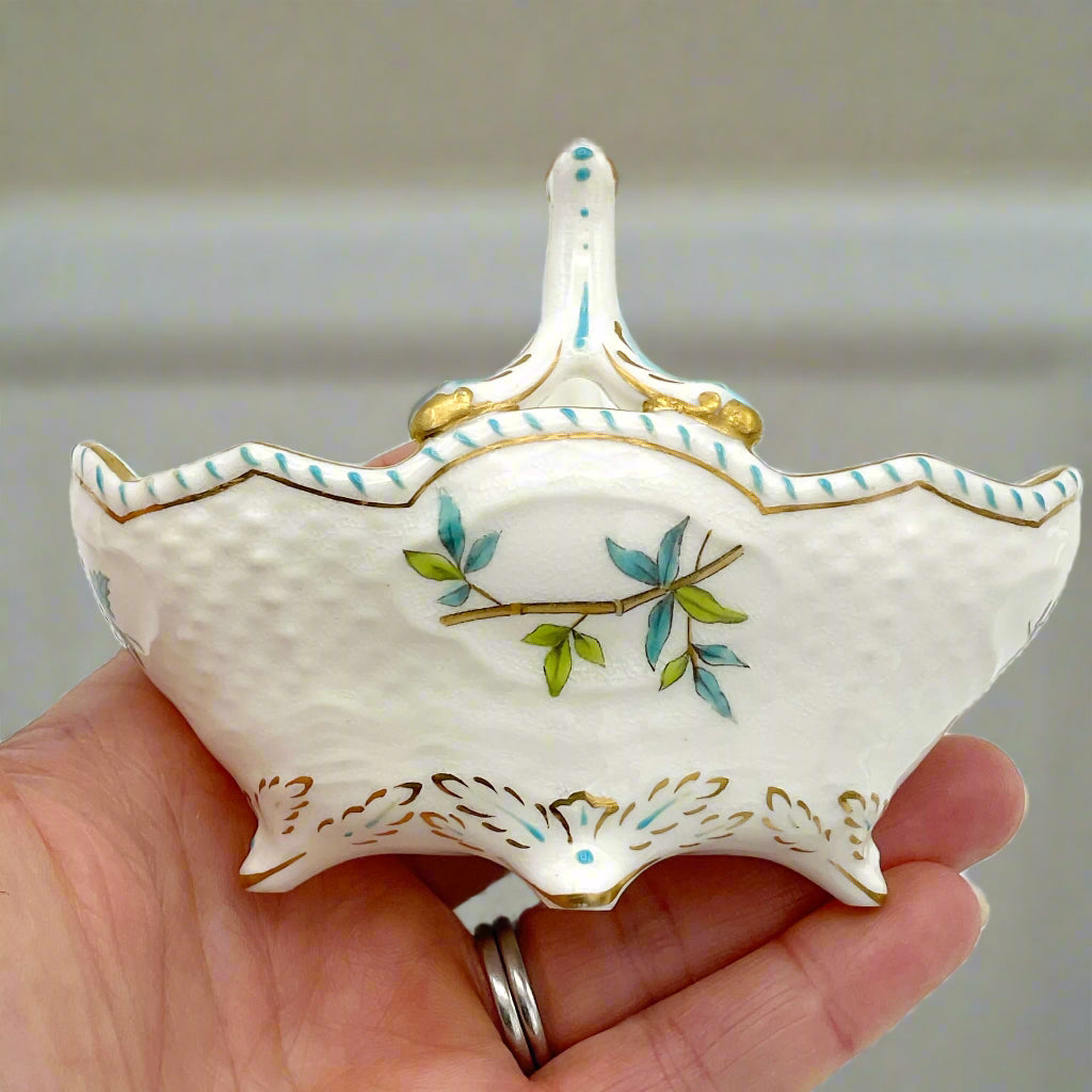 china basket ornament held in a hand with a blurred background