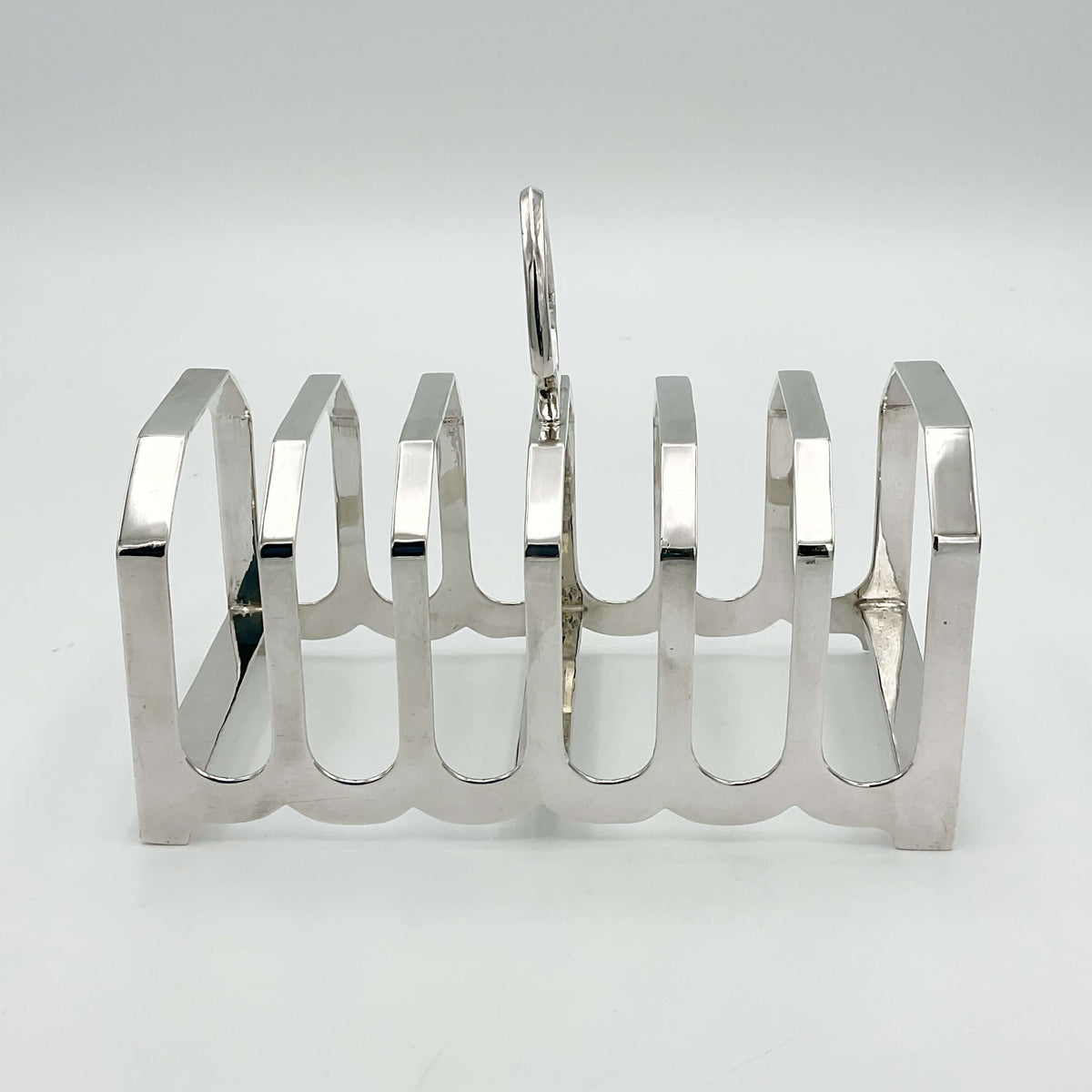 Art Deco sterling silver toast rack from Beeches Vintage with intricate design, vintage 1935 style, showcasing elegant craftsmanship.