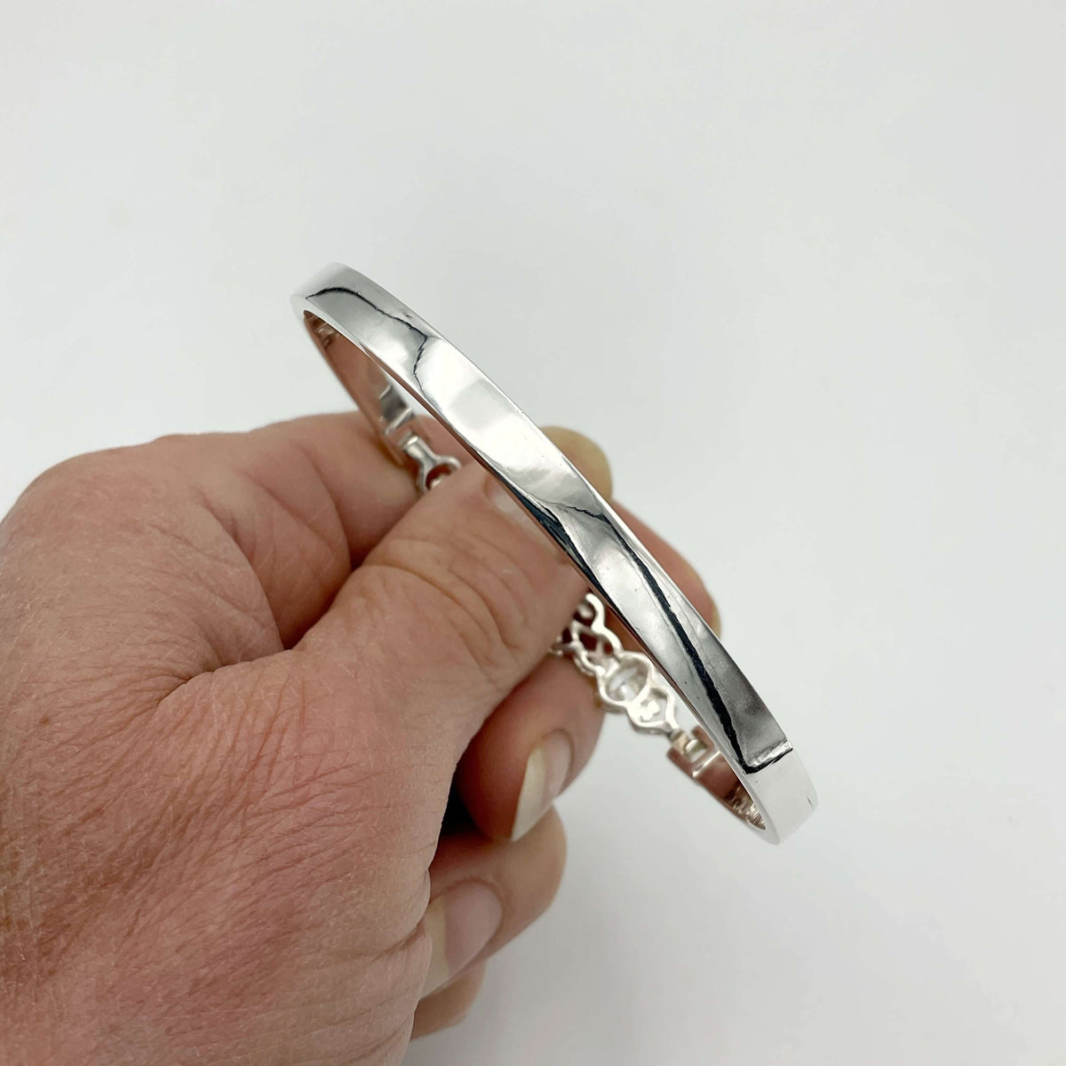 Sterling silver hinged bangle bracelet with cubic zirconia stones from Beeches Vintage, showcasing a shiny, elegant jewelry piece.