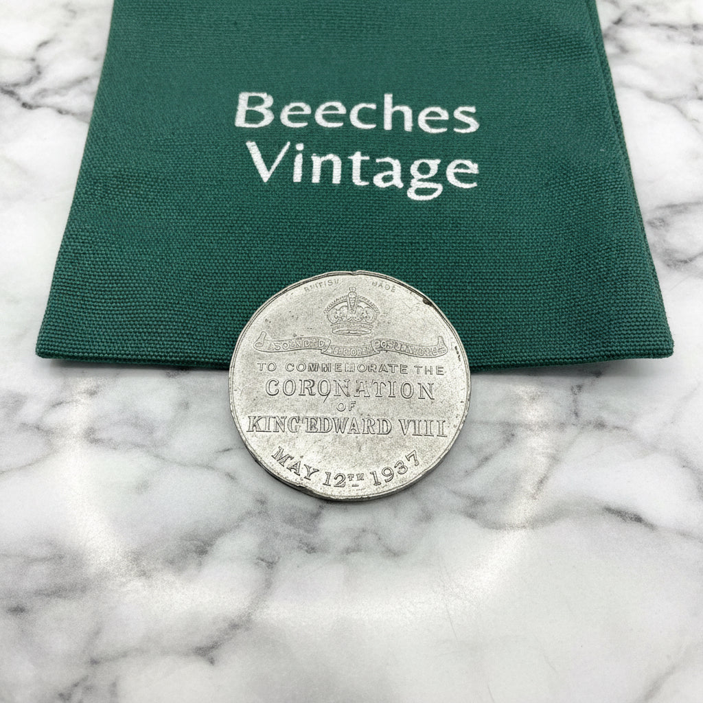 Silver coin on a green cloth with 'Beeches Vintage' branding on a marble surface