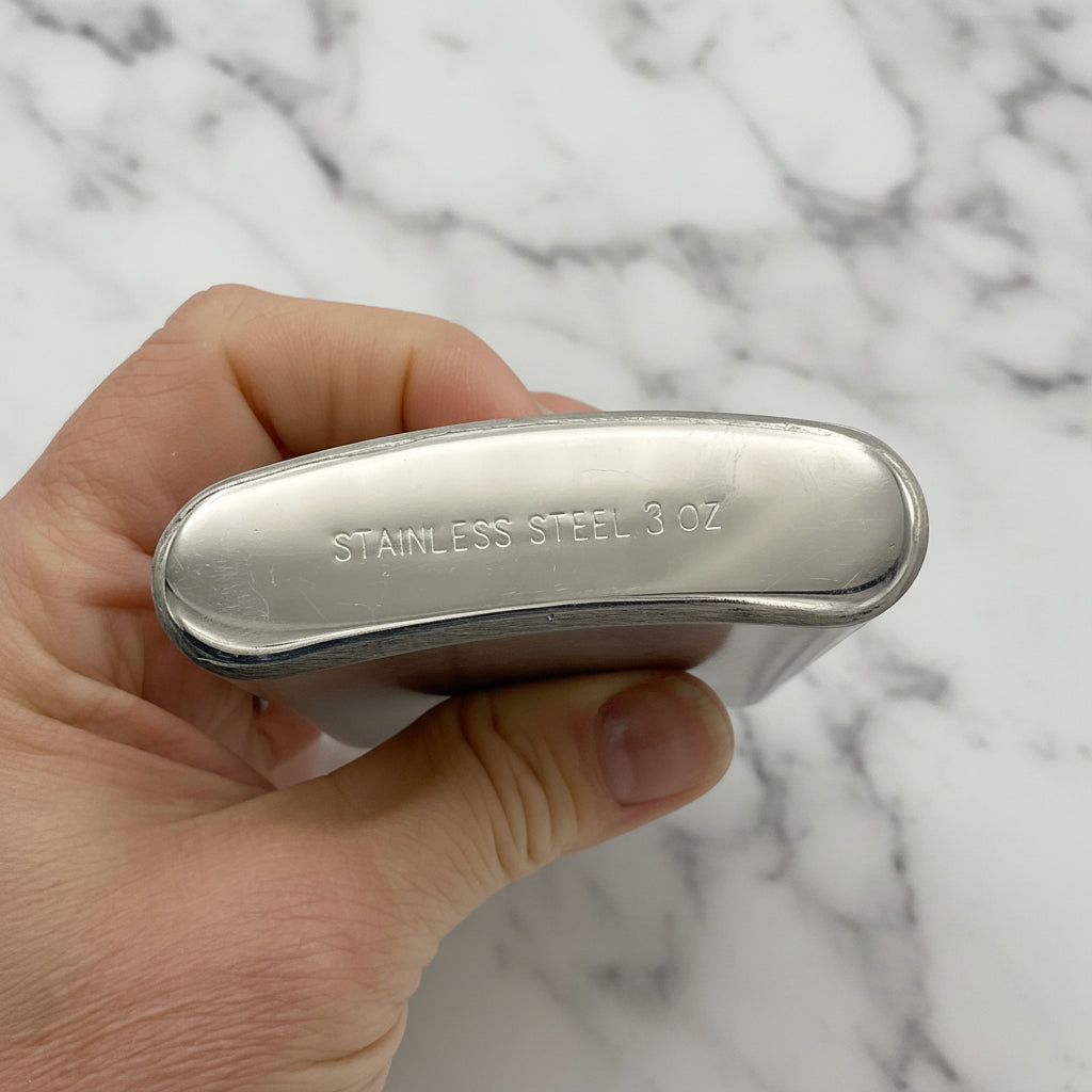 base of hip flask with Stainless Steel 3oz imprinted held in a hand 