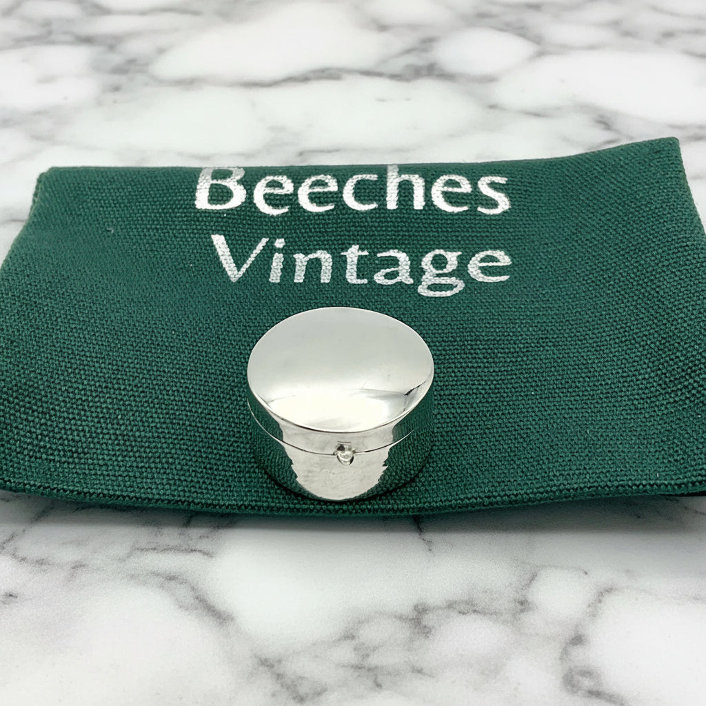 silver pill box on gift bag and marble surface
