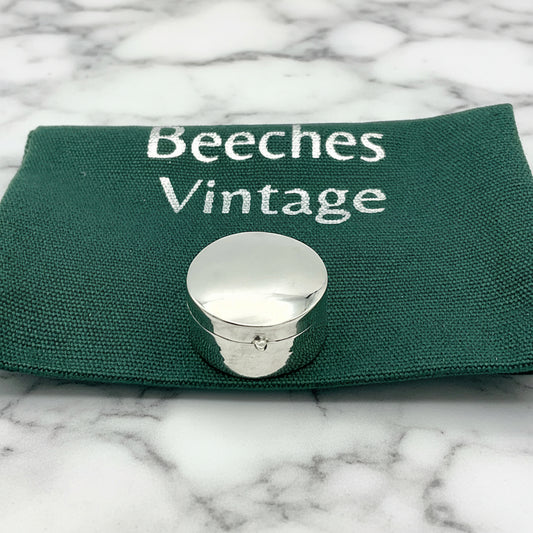 silver pill box on gift bag and marble surface