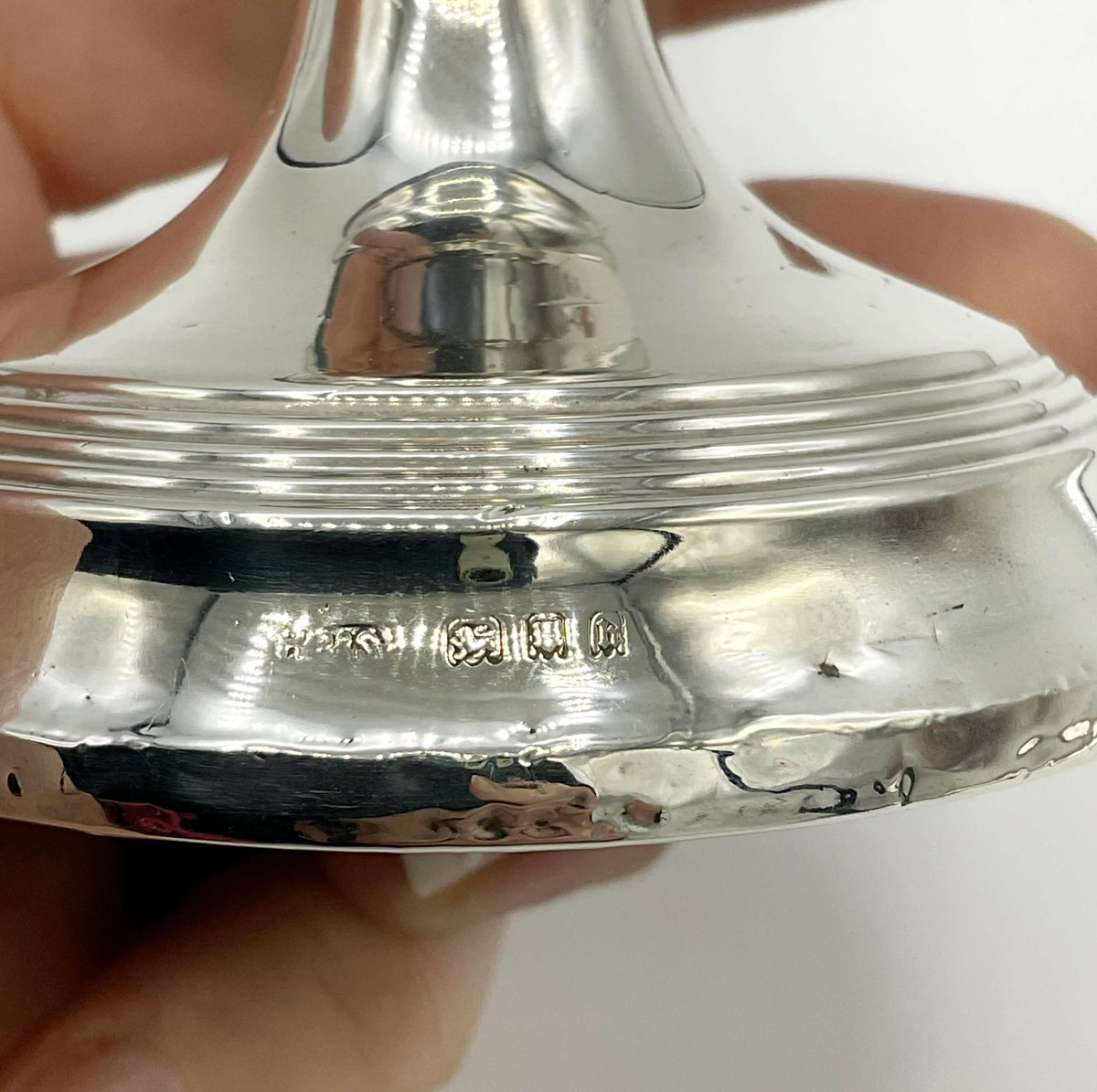 Antique sterling silver candlestick holder from Beeches Vintage with detailed ornate design and a tall, elegant structure.