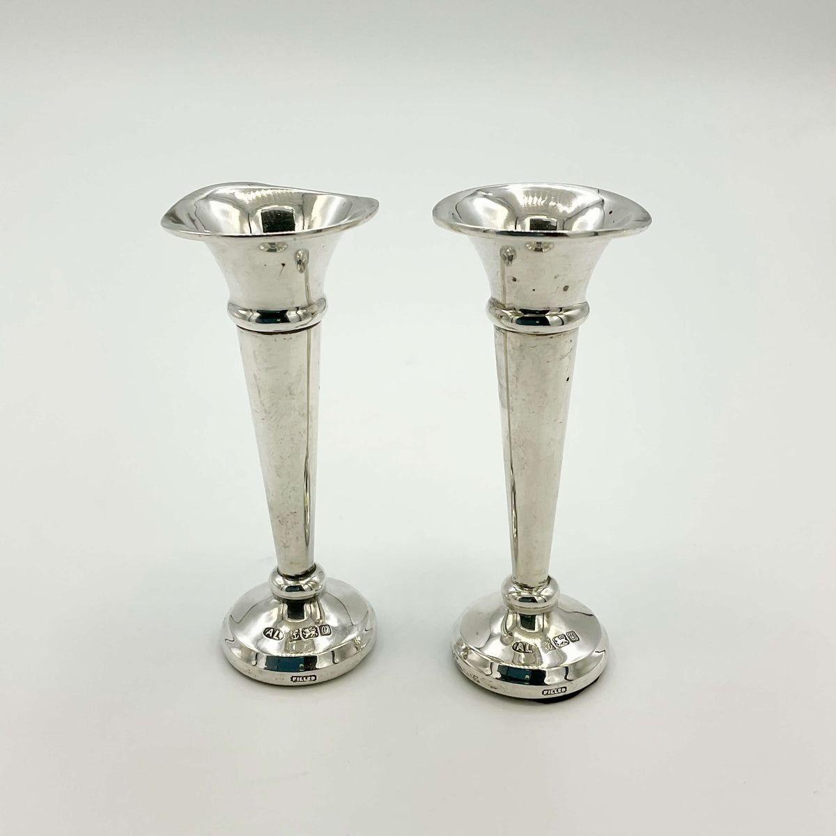 Pair of small sterling silver spill vases by Beeches Vintage, featuring intricate floral engravings and a polished finish.