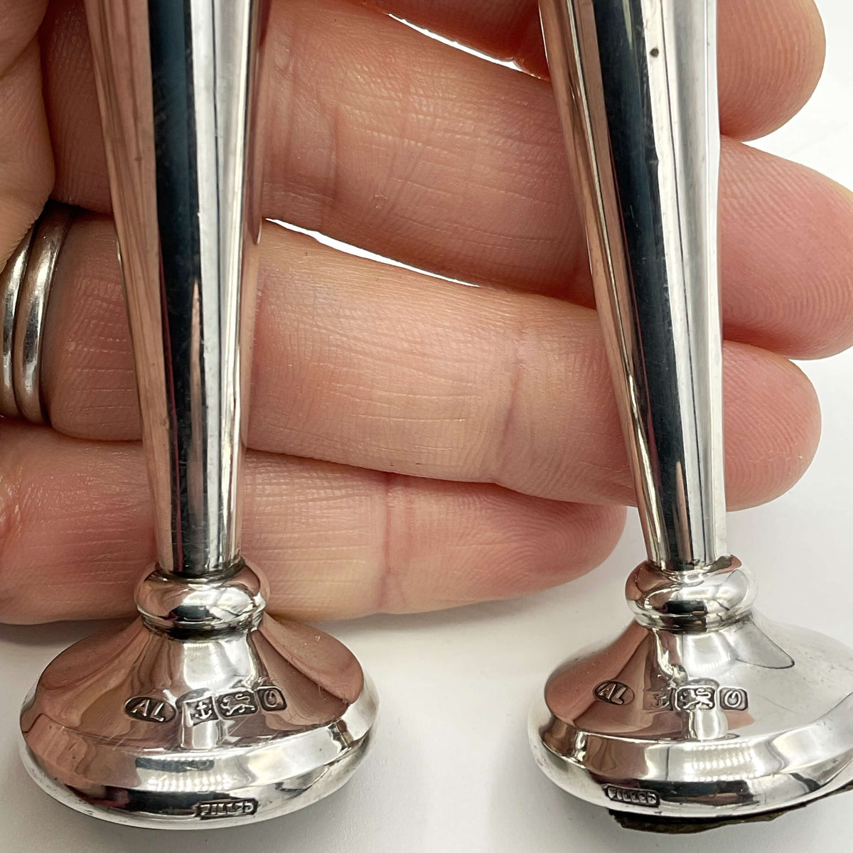 Pair of small sterling silver spill vases with intricate detailing, perfect for decorative floral arrangements.