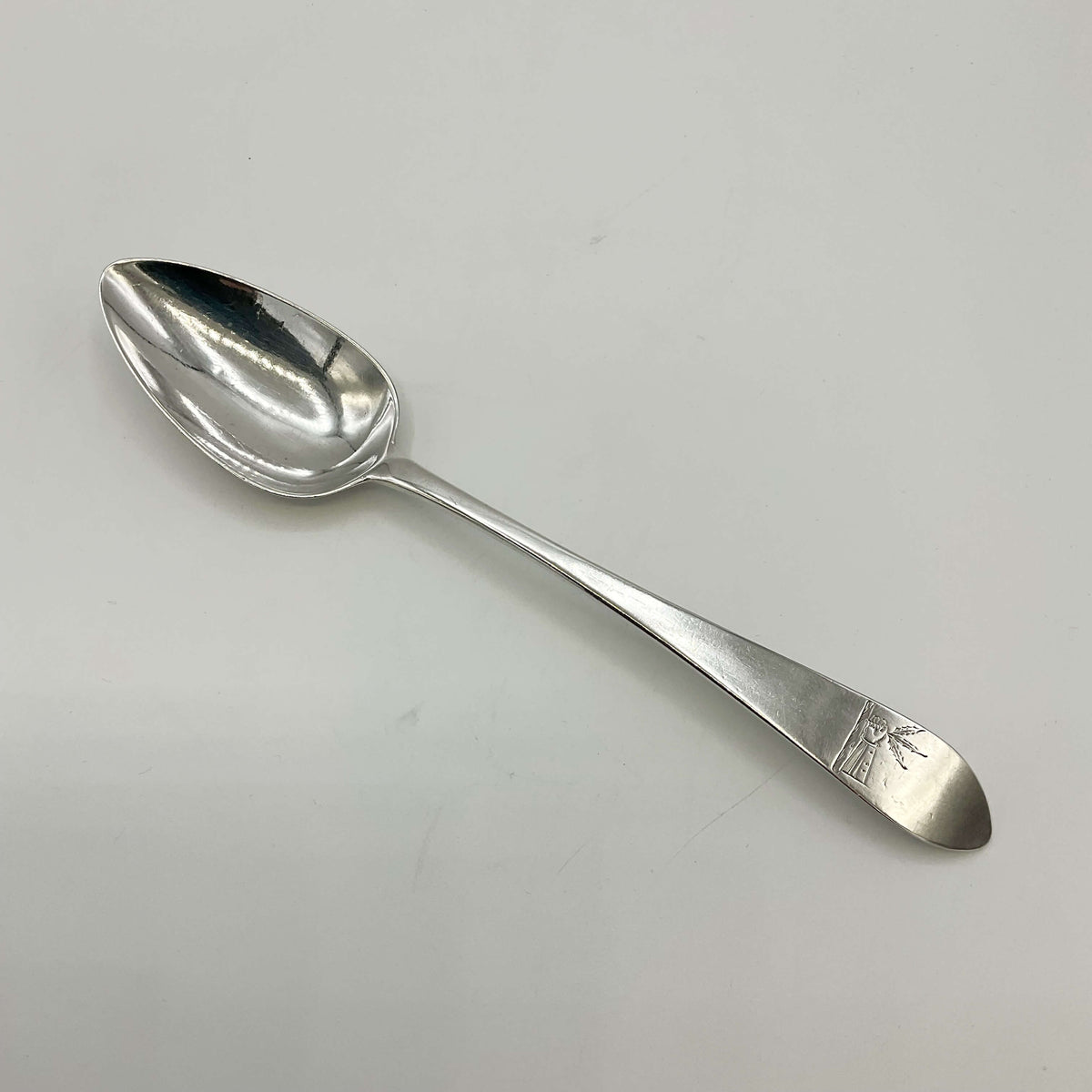 Sterling silver dessert spoon from the 1700s by Beeches Vintage, featuring ornate design and polished surface.