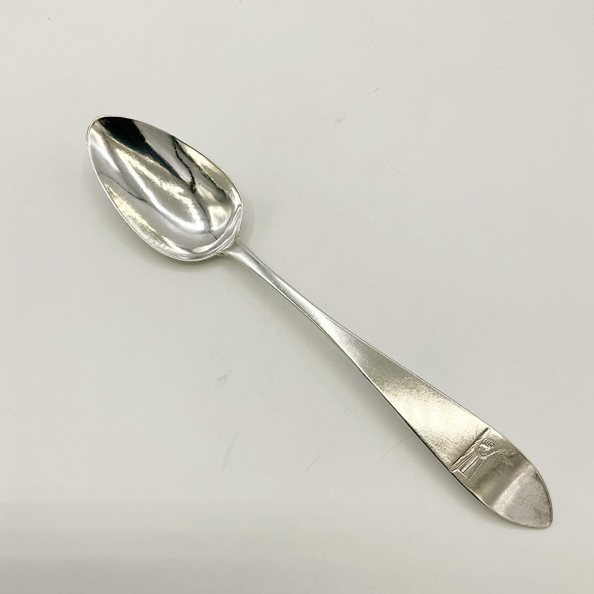 Antique 1700s Georgian sterling silver dessert spoon with ornate handle, from Beeches Vintage, showcasing intricate craftsmanship.