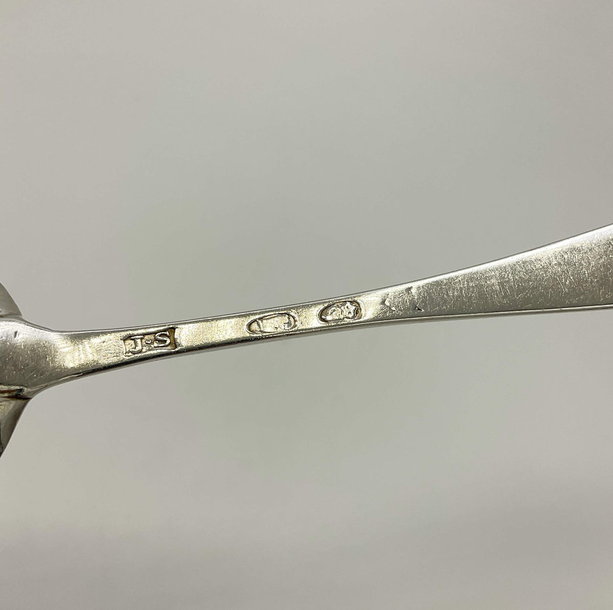 Antique 1700s Georgian sterling silver dessert spoon with ornate handle, from Beeches Vintage, showcasing intricate craftsmanship.