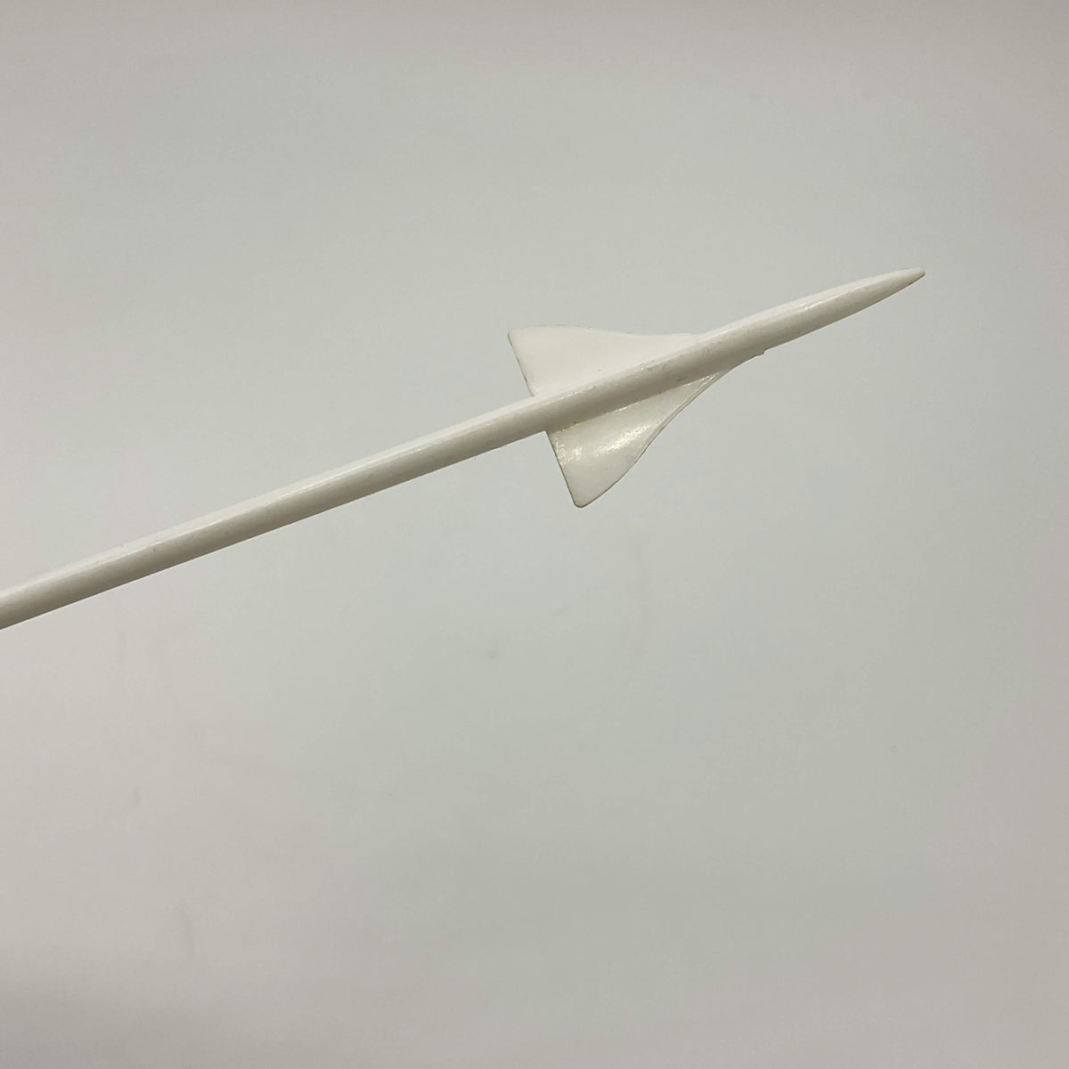 White Concorde Swizzle stick stirrer end in the shape of Concorde with a white background 
