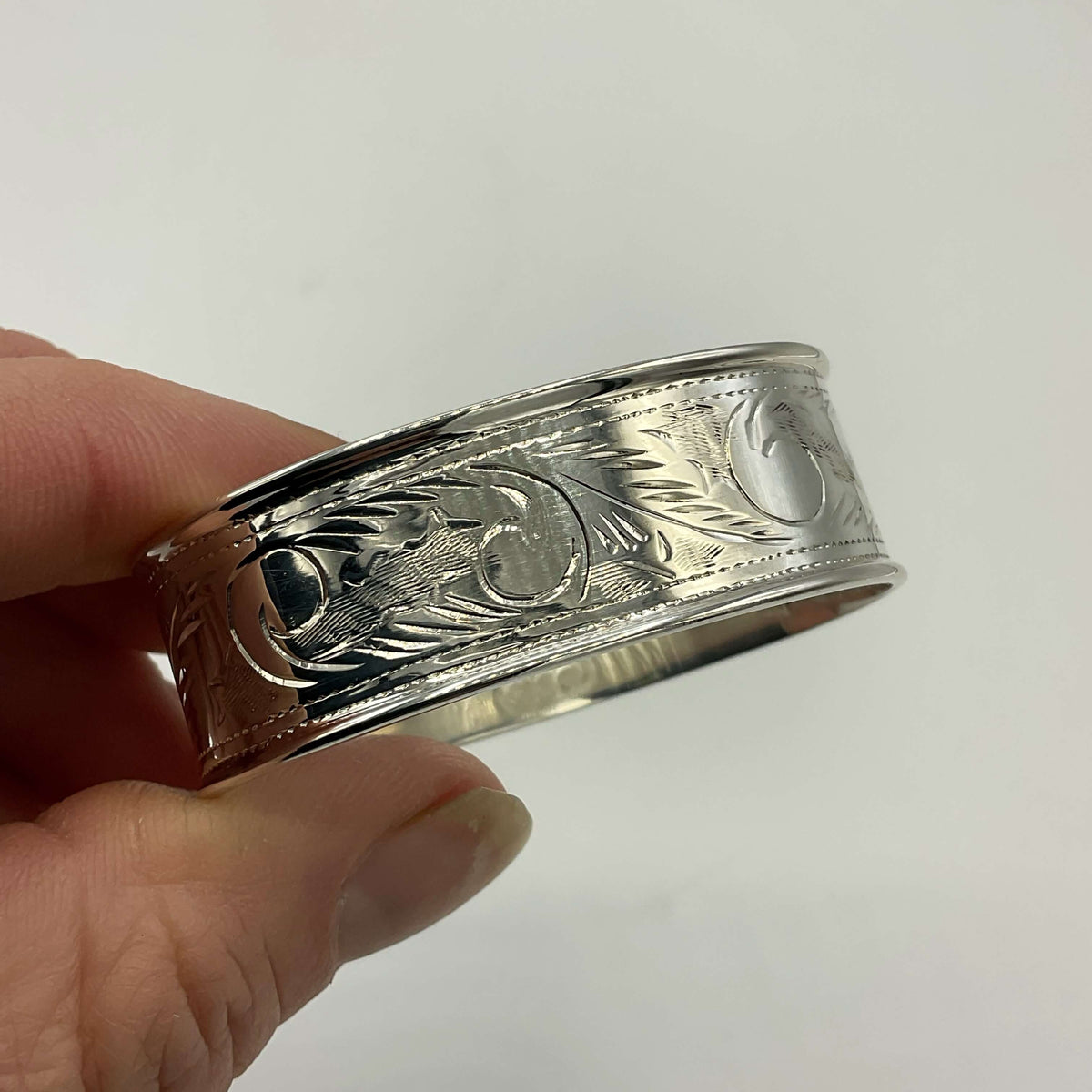 Solid sterling silver napkin ring by Beeches Vintage, featuring intricate engraved design on a polished surface.