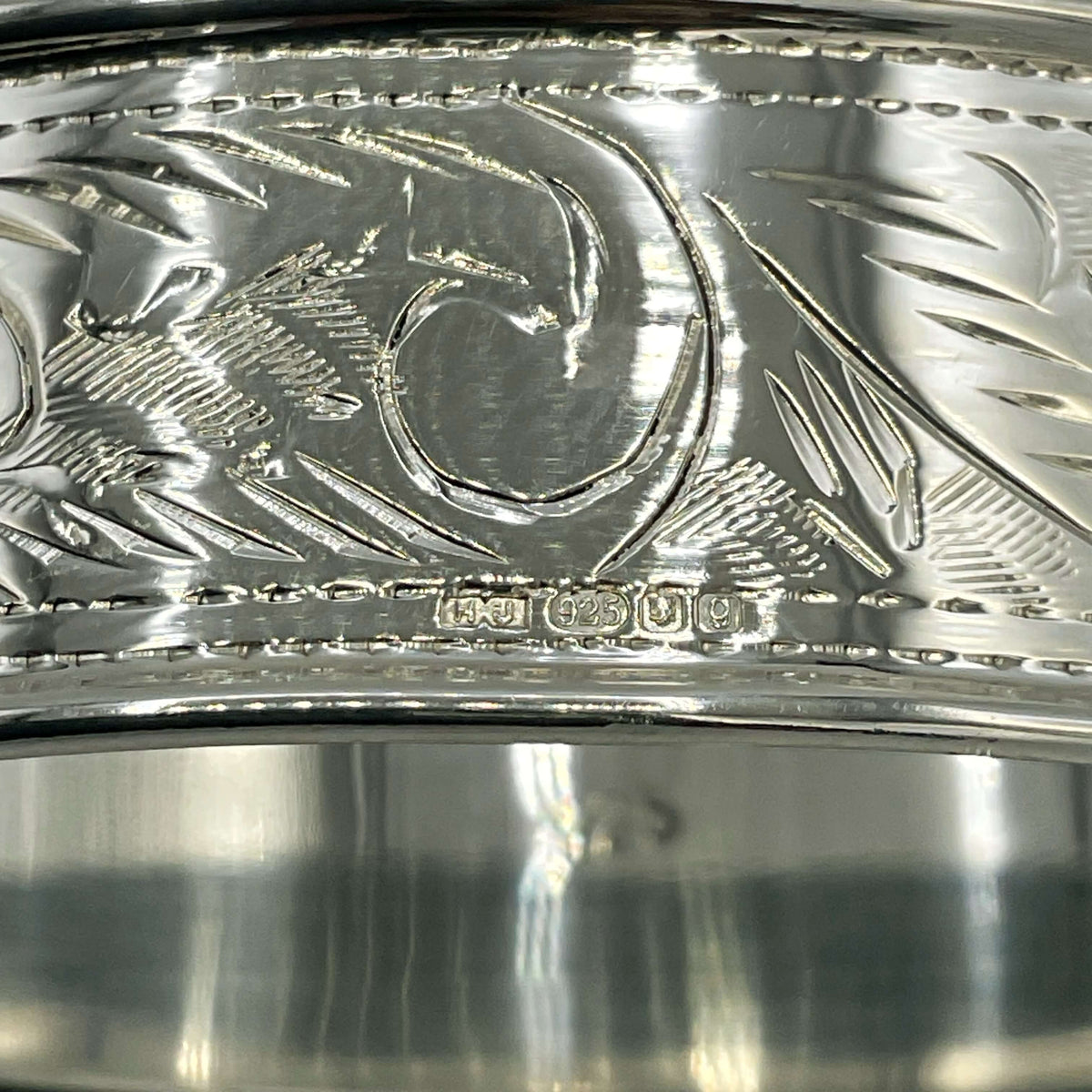 Solid sterling silver napkin ring with intricate design, crafted by Beeches Vintage, displayed on a neutral background.