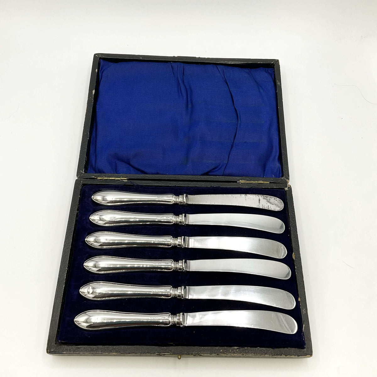 Antique set of silver tea knives in a presentation box with a white background
