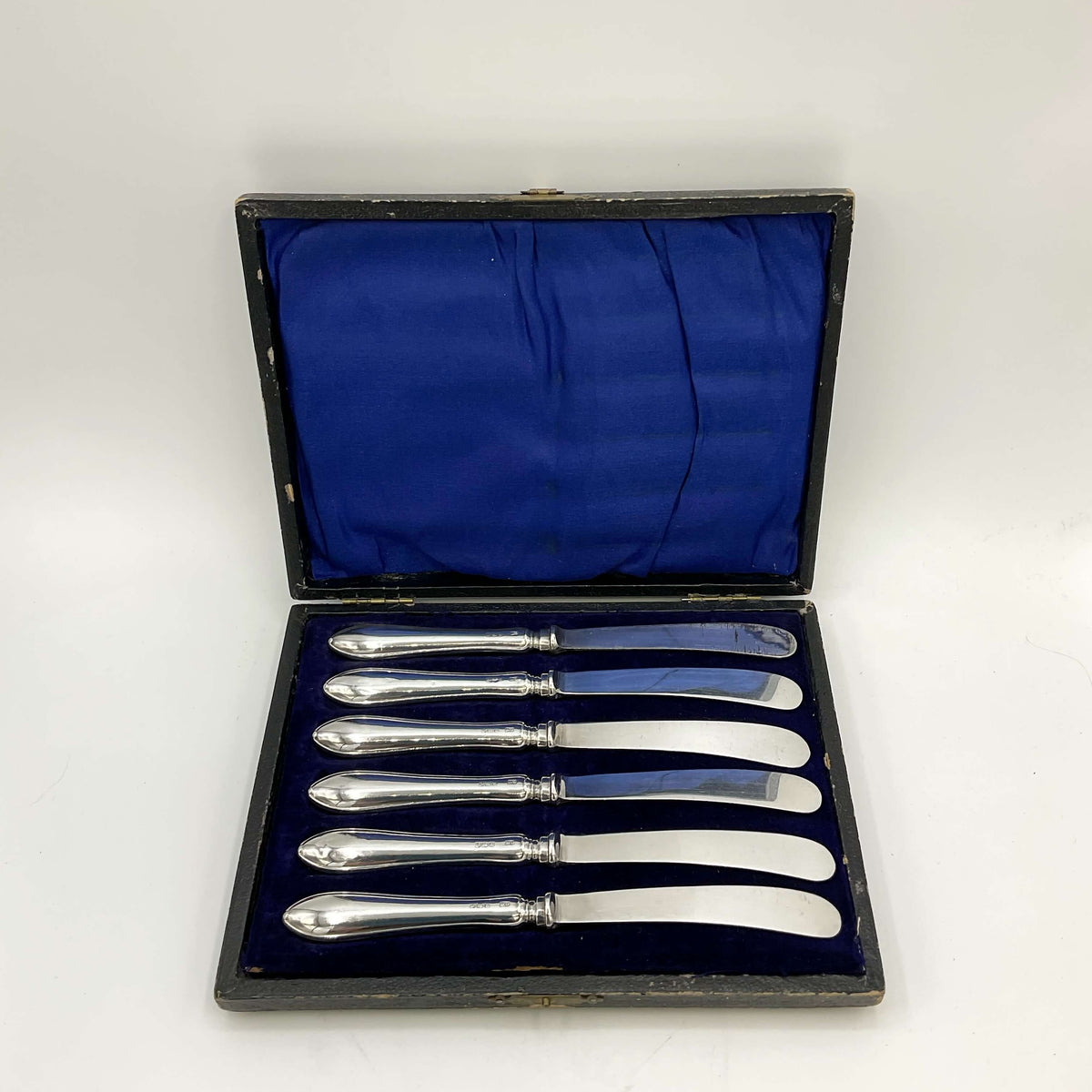 Antique set of silver tea knives in a presentation box with a white background