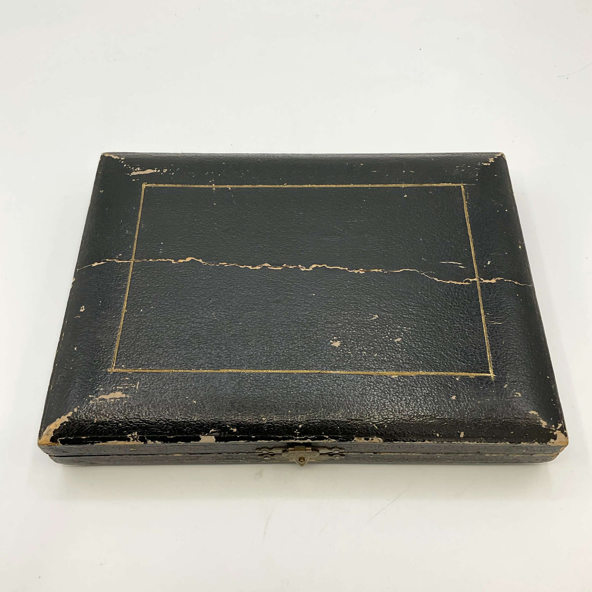 Closed lid of the tea knives box with crack across it on a white background 