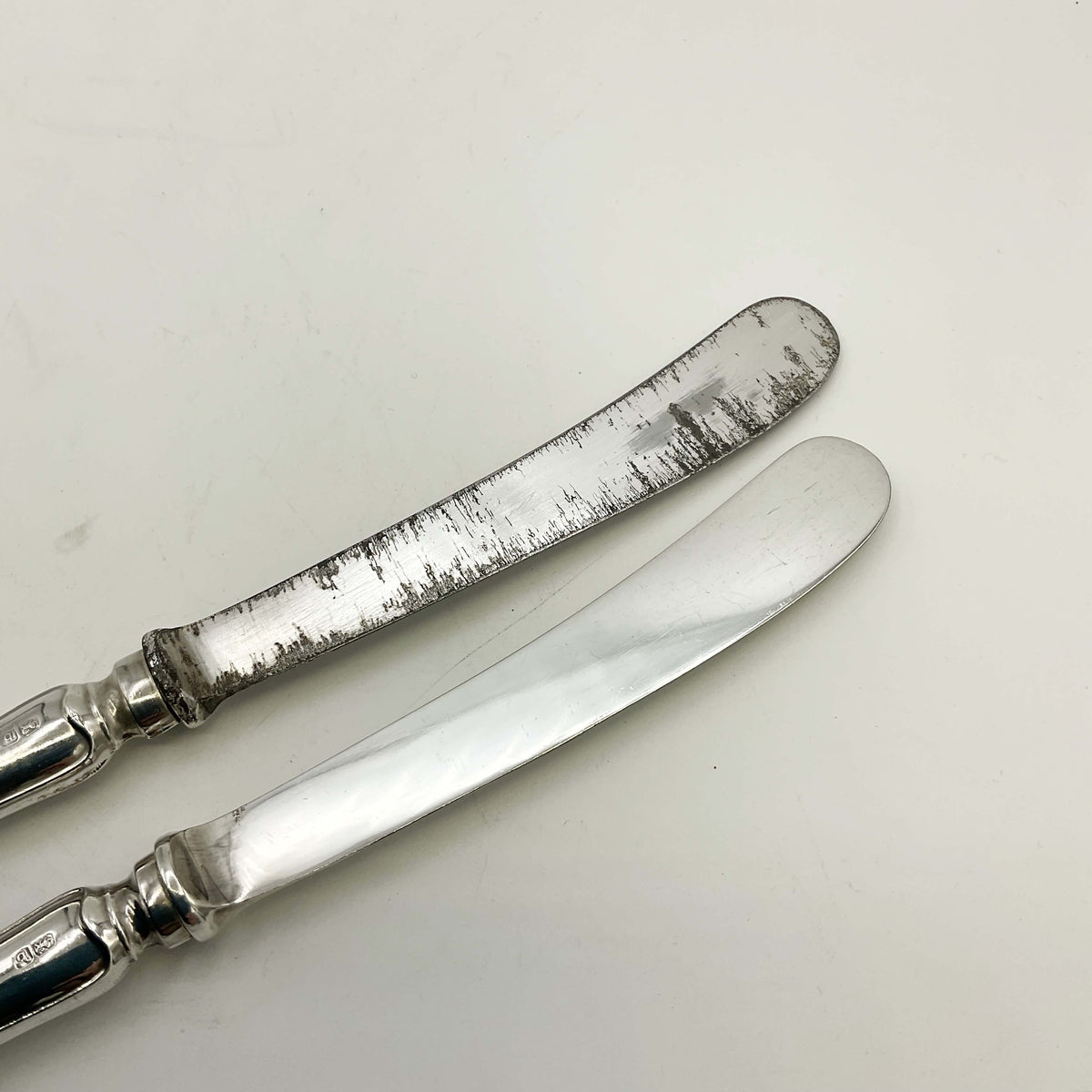 Two blades of tea knives, one with a lot of scratches to it.