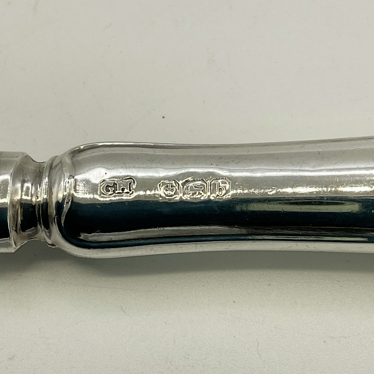 Hallmarks on antique silver tea knife handle showing GH and Sheffield b