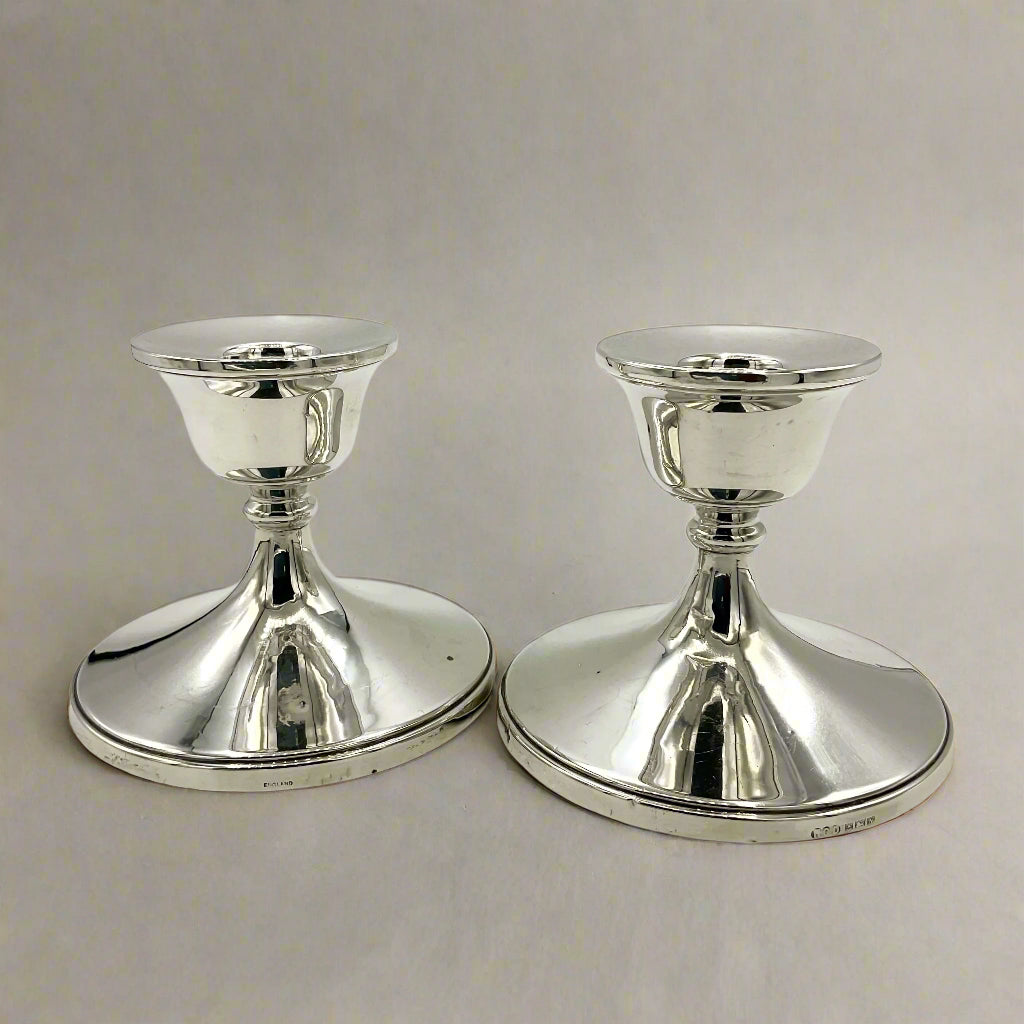 Two silver candle holders on a light gray background