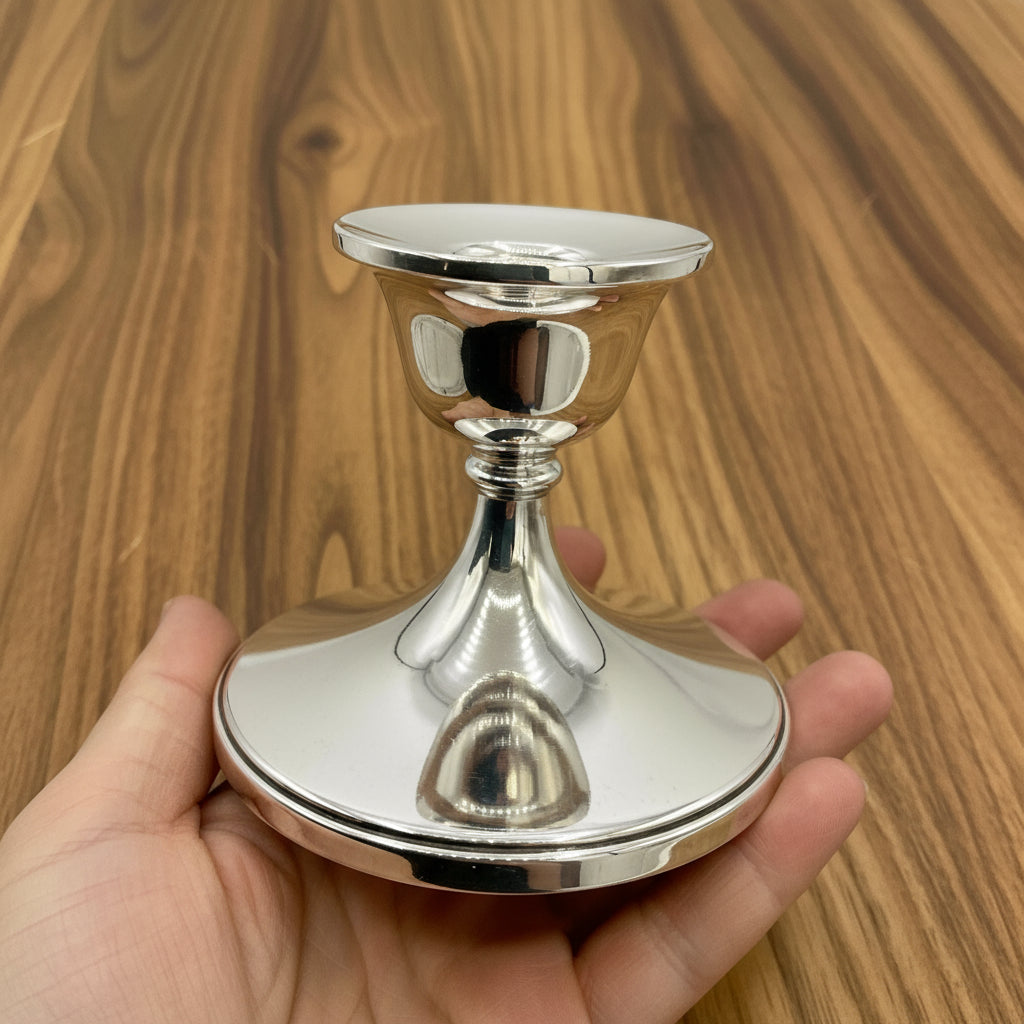 One silver candlestick holder held in a hand