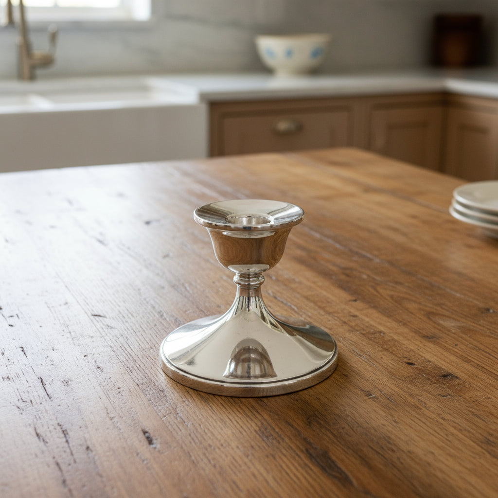 Silver candle holder on a wooden table with a kitchen background