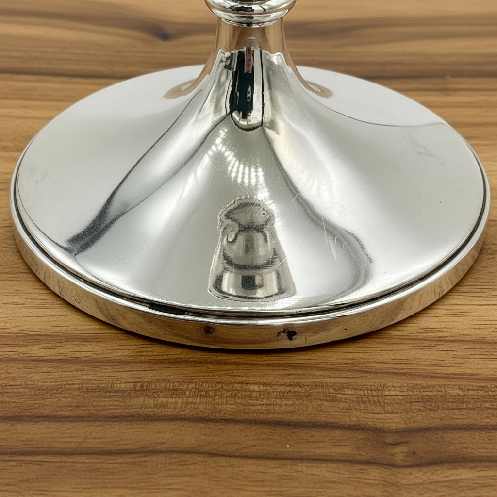 Small dents on the bottom rims of candlesticks on a wood table