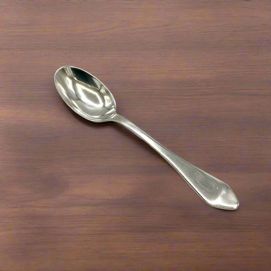 Silver coffee spoon on a wood table