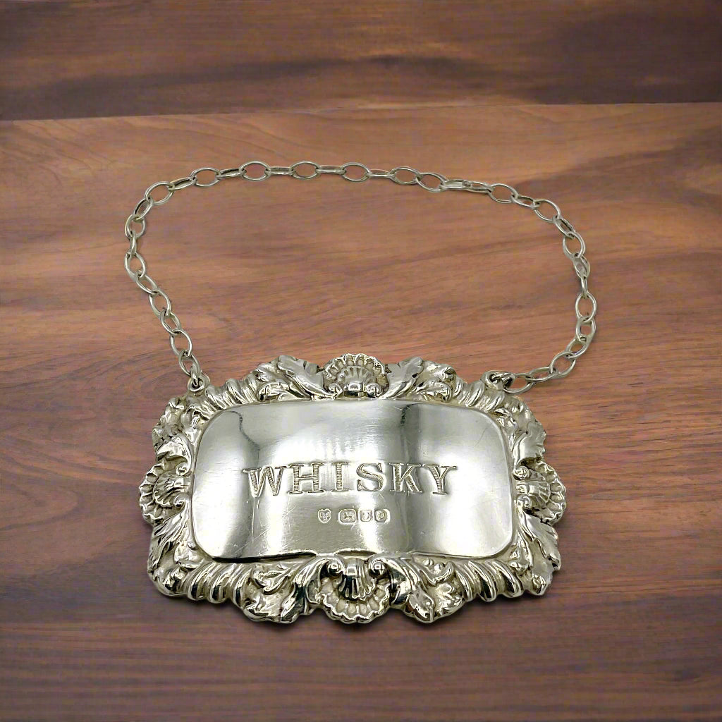 Silver whisky decanter label on a wooden table