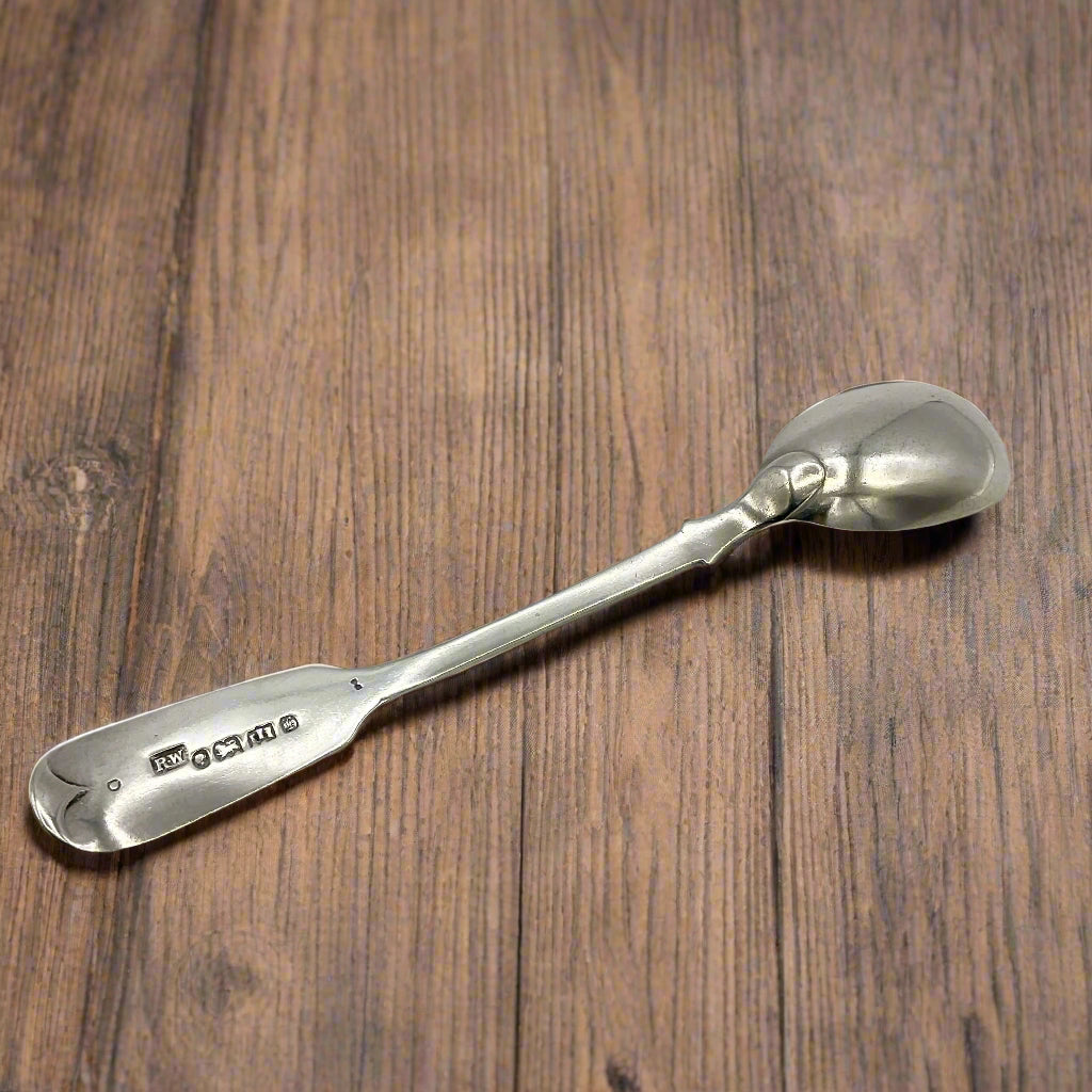 Antique salt spoon lying upside  down on a wood table