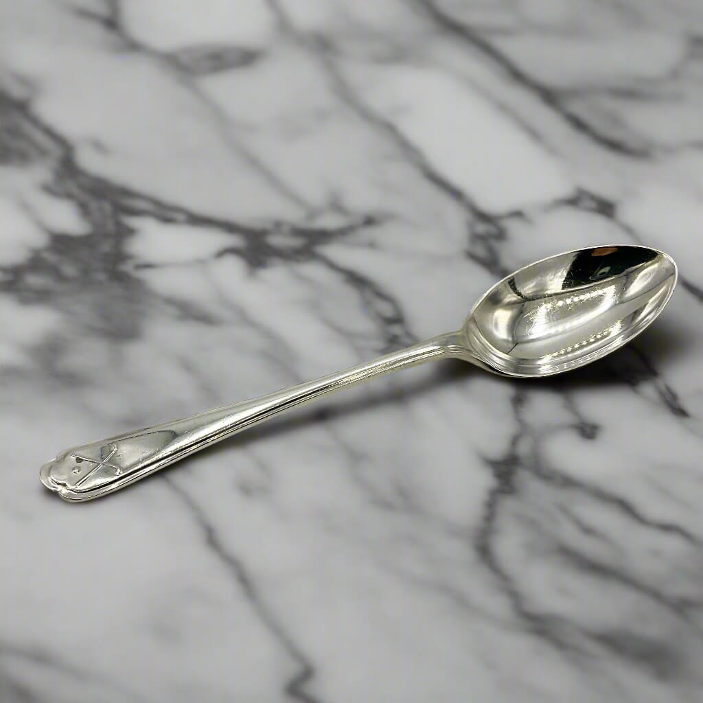Silver coffee spoon on a marble worktop