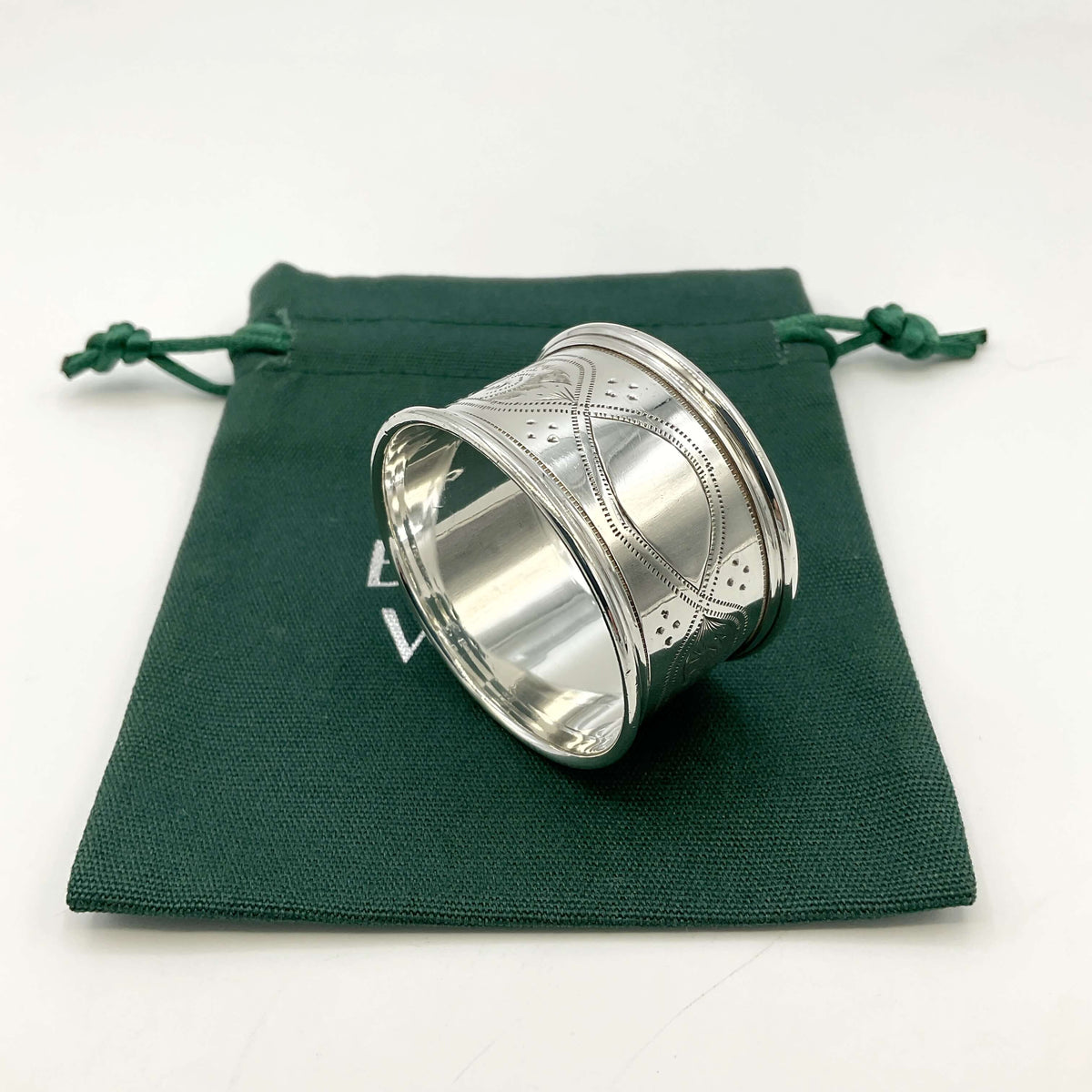 Antique silver napkin ring on a green gift bag and white background 