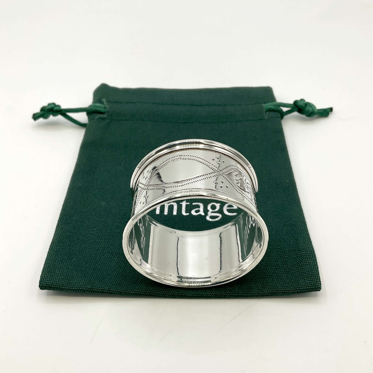 Antique silver napkin ring on a green gift bag and white background 
