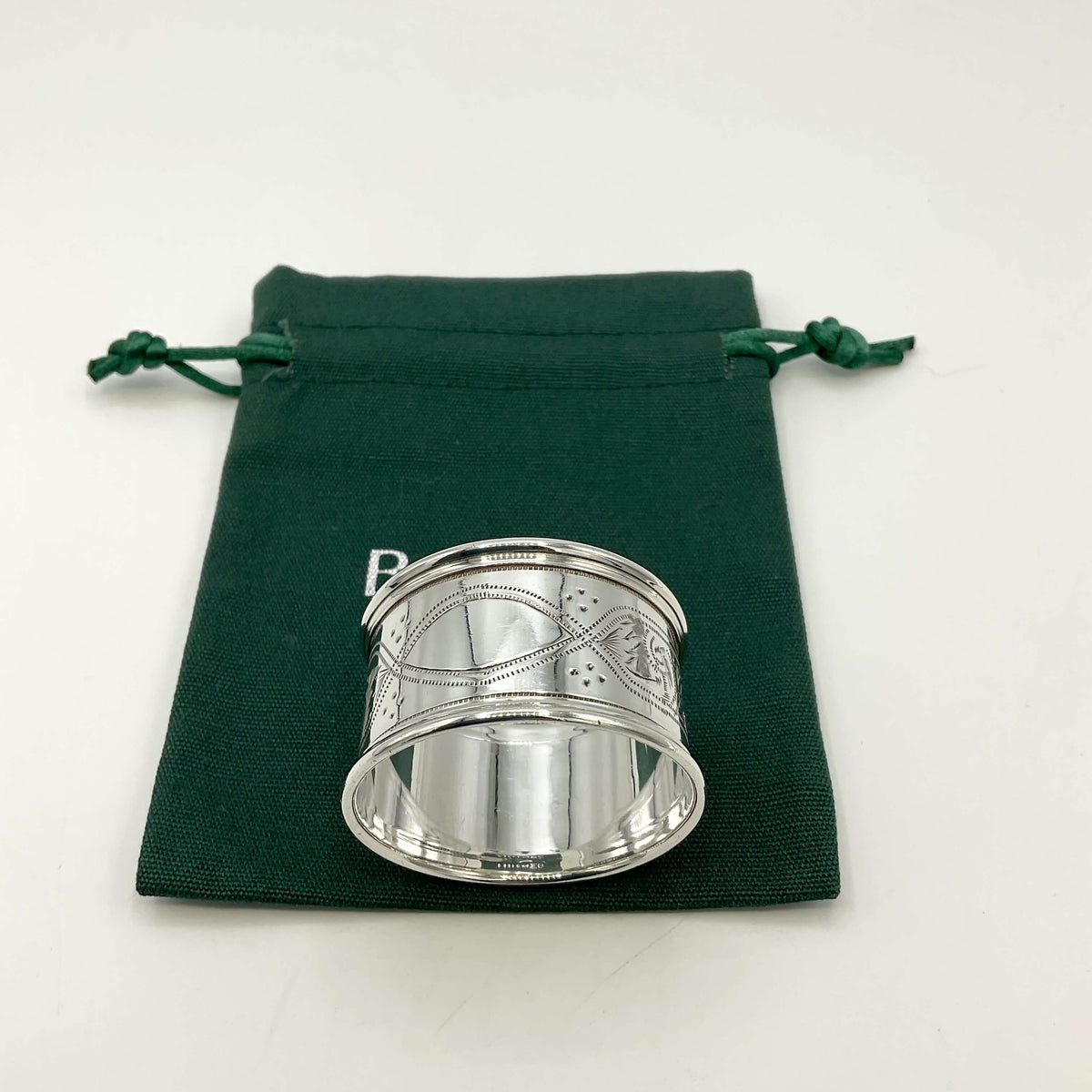 Antique silver napkin ring on a green gift bag and white background 