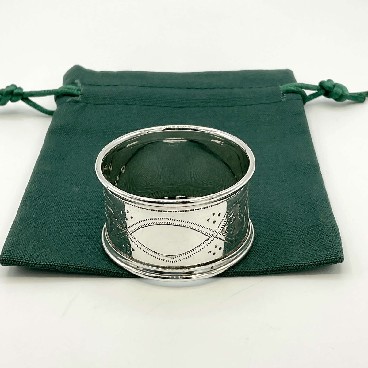Antique silver napkin ring on  a green gift bag and white background 