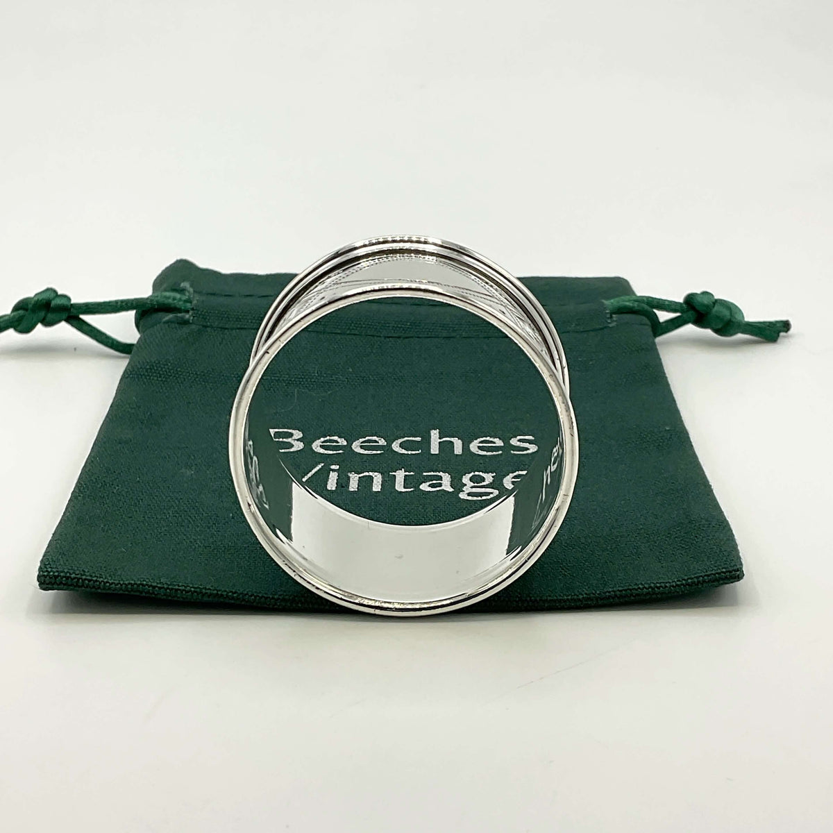 Inside of Antique silver napkin ring on a green gift bag and white background 