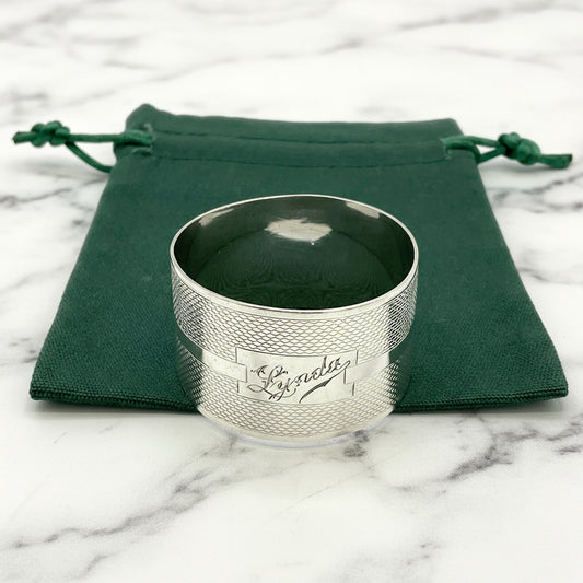 Silver napkin ring with Lynda on on the front on a gift bag on a white background 