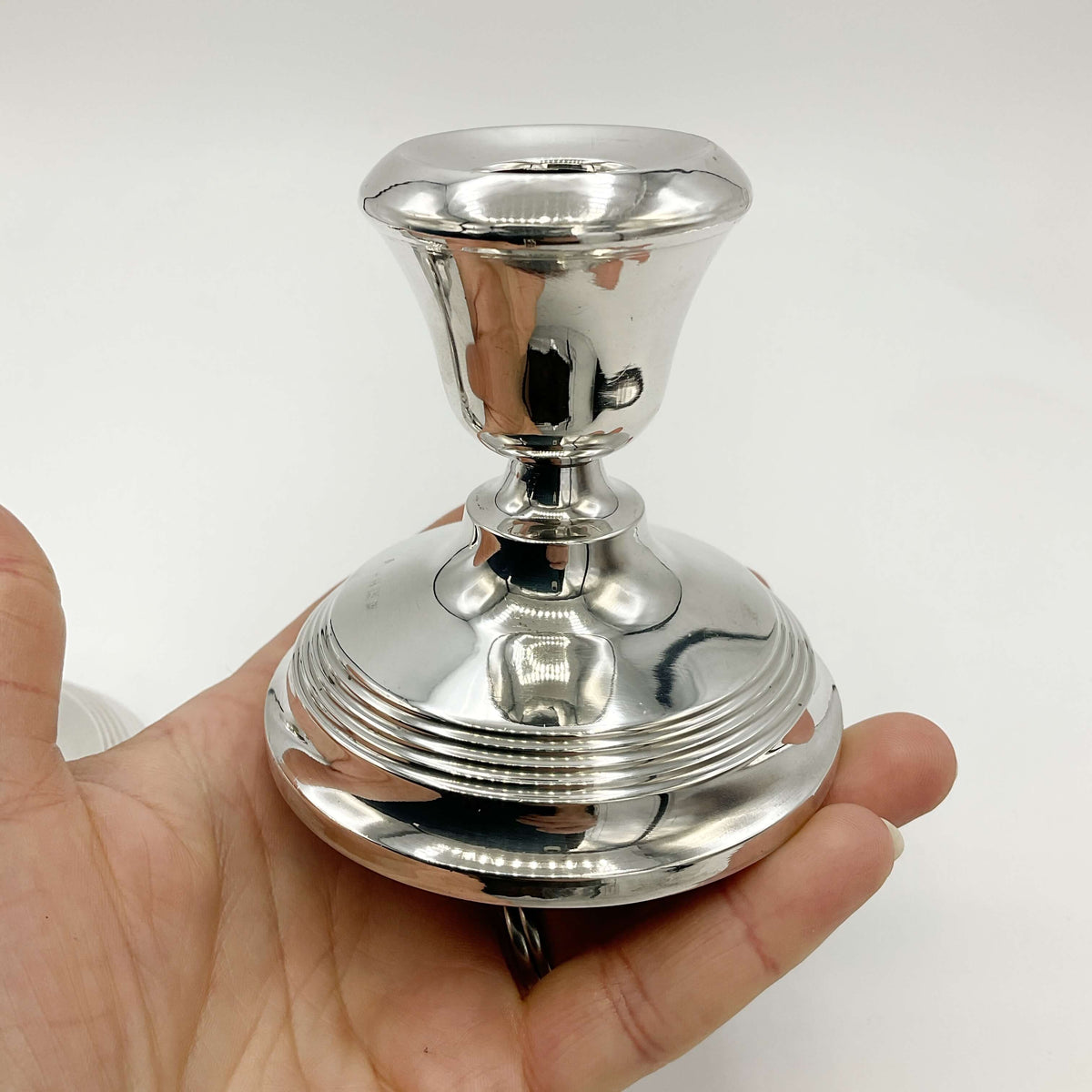 silver candle holder held in a hand