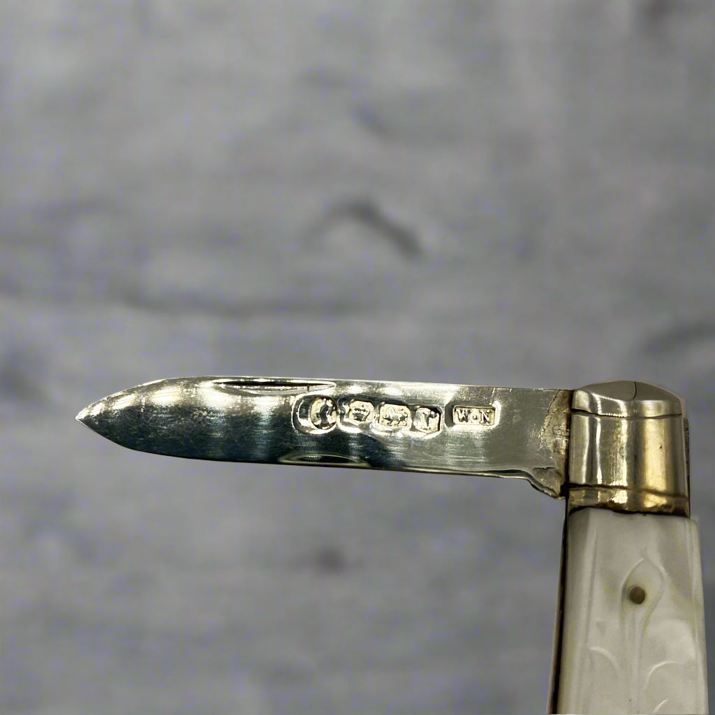 Sterling silver fruit knife by Beeches Vintage with intricate engraved handle and sharp blade for precise cutting.
