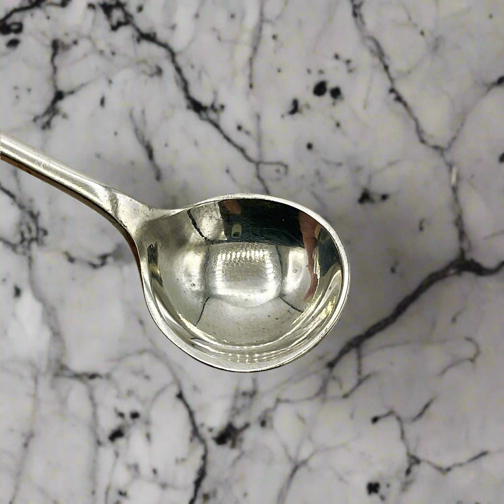 Silver spoon bowl on a marble worktop 